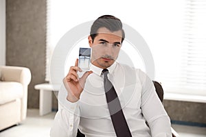 Handsome young man with bottle of perfume