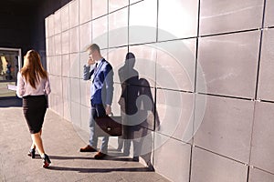 Handsome young man, businessman talking on phone passes by beaut