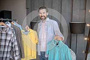 Handsome young man choosing a tshirt for today.