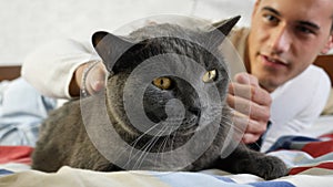 Handsome Young Man Cuddling his Gray Cat Pet