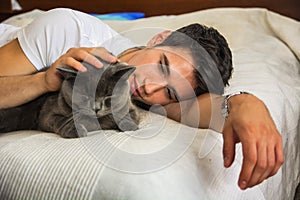 Handsome Young Man Cuddling his Gray Cat Pet