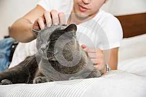 Handsome Young Man Cuddling his Gray Cat Pet