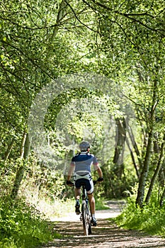 Handsome young man cycling in the mountain.