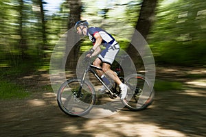 Handsome young man cycling in the mountain.