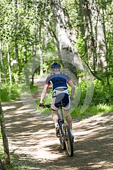 Handsome young man cycling in the mountain. photo