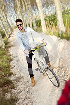 Handsome young man cycling in the park.