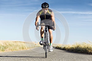 Handsome young man cycling on the road. photo