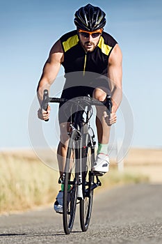 Handsome young man cycling on the road. photo