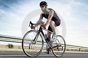 Handsome young man cycling on the road. photo