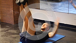 Handsome young man doing abs exercises on mat