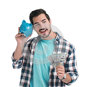 Handsome young man with dollars and piggy bank