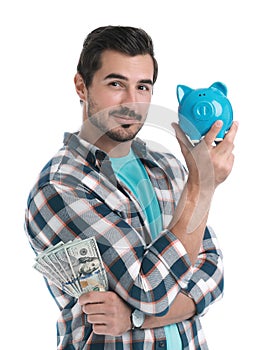 Handsome young man with dollars and piggy bank