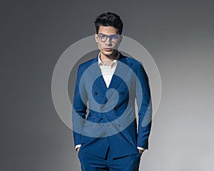 handsome young man in double breasted blue suit holding pockets