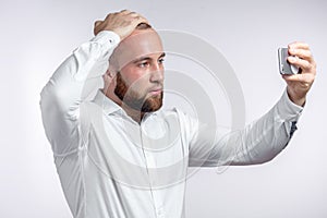 Handsome young man dressed in shirt taking selfie isolated over white background