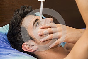 Handsome young man dropping medicine in his eye