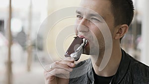 Handsome young man eating a chocolate ice-cream