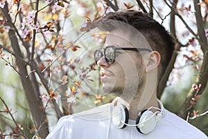 Handsome young man enjoying the beauty of the blossoming trees