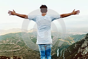 Handsome young man enjoying nature at mountain peak.