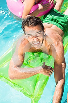 Handsome young man enjoying in the swimming pool