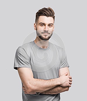 Handsome young man with folded arms isolated portrait. Joyful cheerful smiling  men with crossed hands studio shot