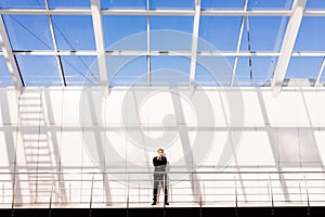 Handsome young man in full suit while standing modern office hall