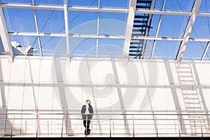 Handsome young man in full suit while standing modern office hall