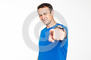 Handsome young man gesturing with his hand, pointing finger at you, isolated on white background