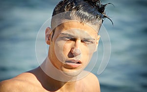 Handsome young man getting out of water with wet hair