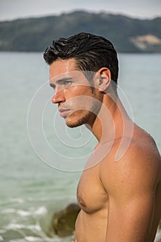 Handsome young man getting out of water with wet hair