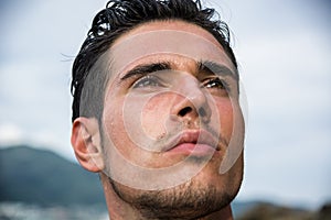 Handsome young man getting out of water with wet hair