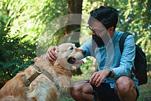 Handsome young man with golden retriver outdoors