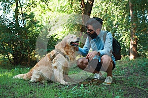 Handsome young man with golden retriver outdoors