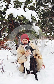 Handsome young man with his boxer dog outdoors