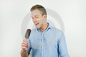 Handsome young man holding chololate ice-cream on isolated white background