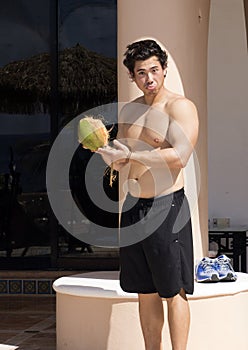 Handsome young man holding a coconut