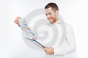 Handsome young man holding a folder and looking at the diagrama photo
