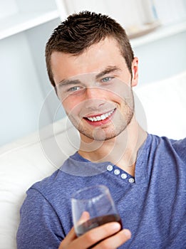 Handsome young man holding a glass of wine