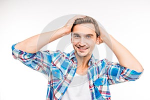 Handsome young man holding hands on his hair