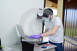 Handsome young man installing anti burglary alarm at a client house with a surgical mask and gloves COVID19 coronavirus