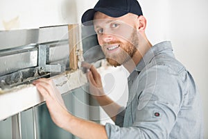 handsome young man installing window