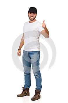 Handsome Young Man In Jeans, White T-shirt And Black Cap Is Showing Thumb Up
