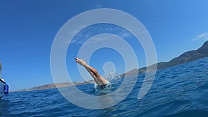 Handsome young man jumping from a boat or yacht into the sea or ocean. Summer vacation with friends. Tourists have fun