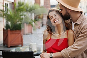 Handsome young man kissing his beautiful girlfriend on city street