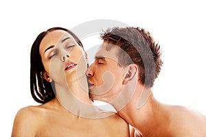 Handsome young man kissing woman`s neck.