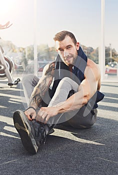 Handsome young man lace shoes at gym after training