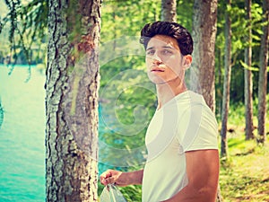 Handsome young man on a lake in a sunny, peaceful