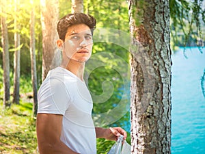 Handsome young man on a lake in a sunny, peaceful