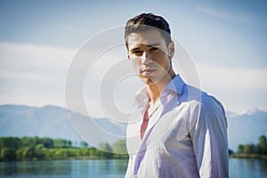 Handsome young man on a lake in a sunny, peaceful