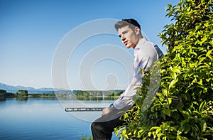 Handsome young man on a lake in a sunny, peaceful