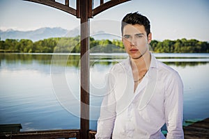 Handsome young man on a lake in a sunny, peaceful